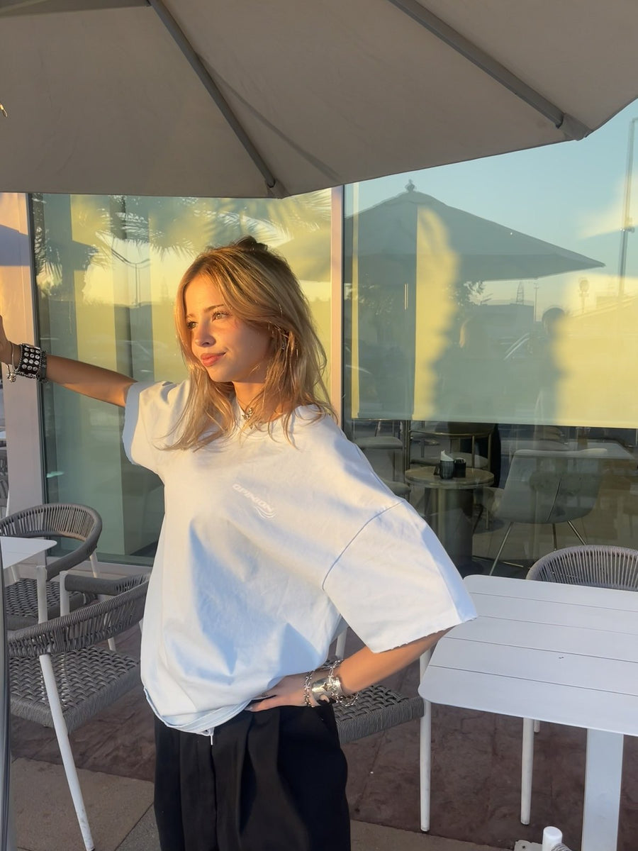 Model wearing the baby blue Past x Future tee at sunset